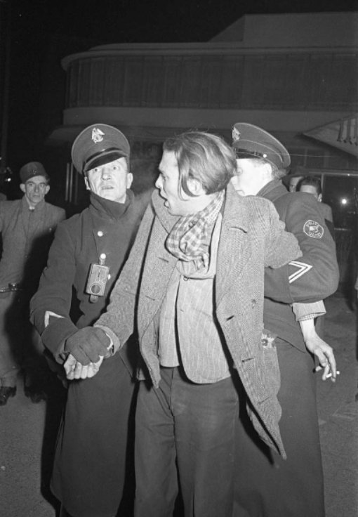Stadtarkiv Karlsruhe, A police officer leading away a perpetrator. On the sleeve of the uniform is the bilingual badge 