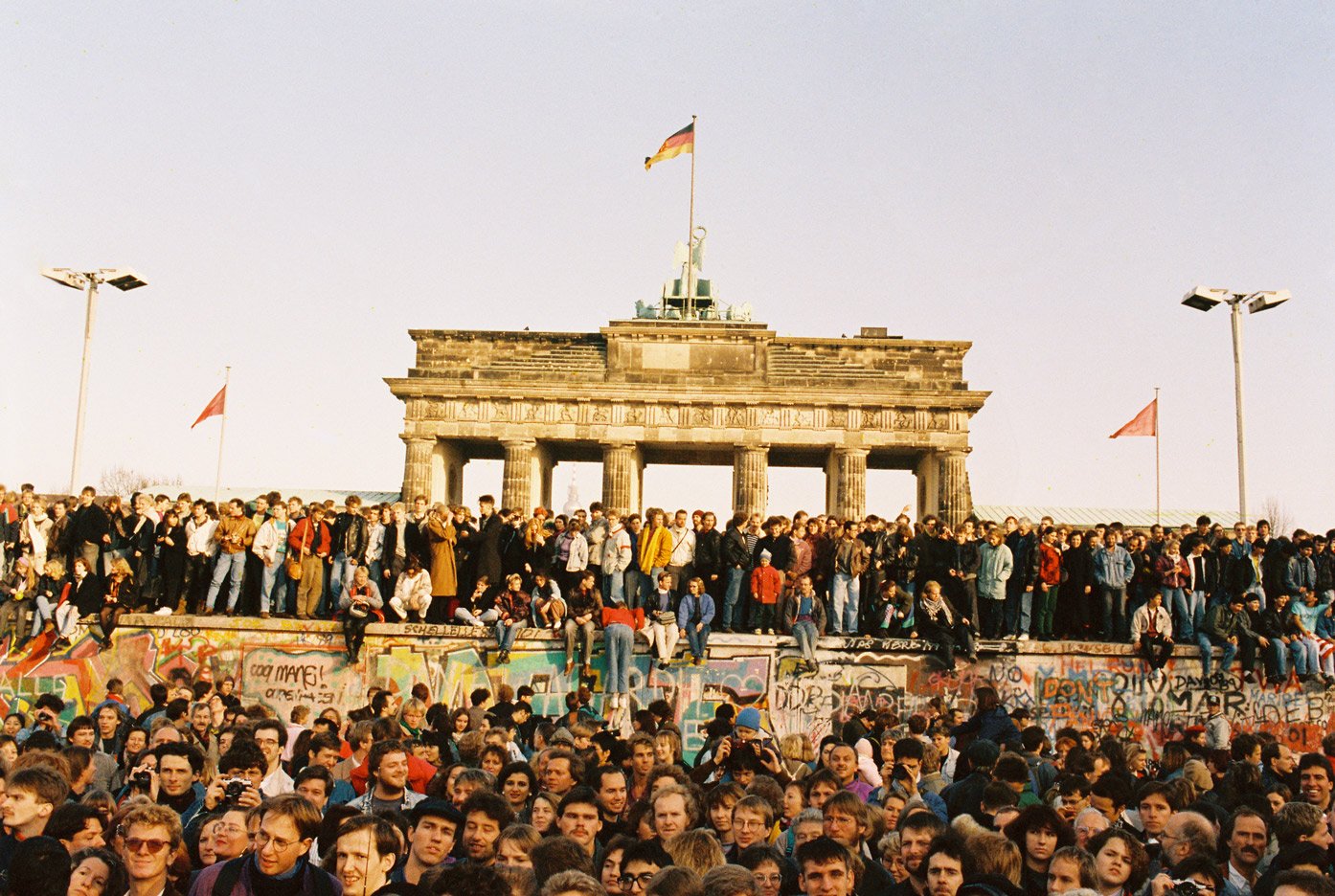 People on top of the Berlin Wall in front of the Brandenburg Gate on 10 November 1989