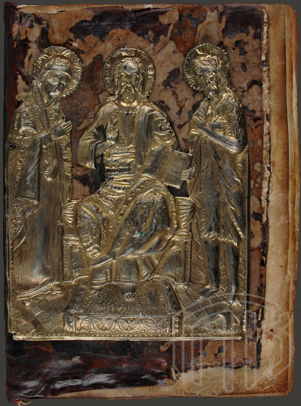 A relief silver later plaque has been attached on the front cover, which presents Jesus Christ holding the Gospel on his left hand and blessing with the right hand, flanked by the Virgin Mary and Saint John the Baptist.